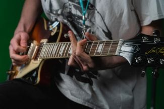 Optagonen Deltagare spelar in gitarr