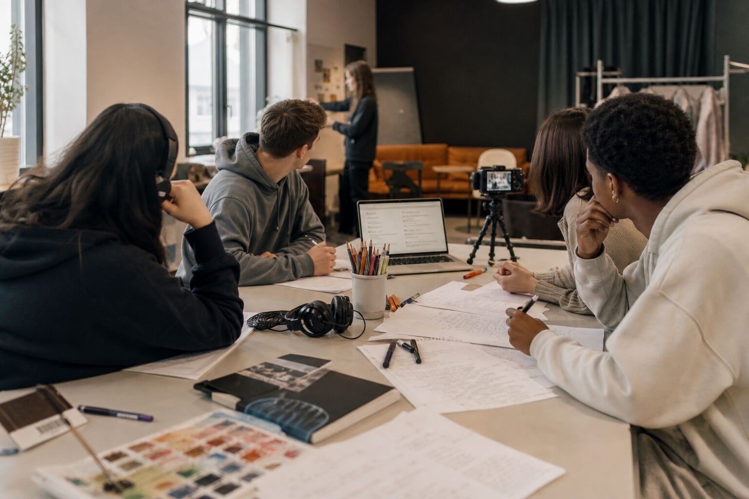 Unga deltar i en kreativ workshop med skrivande, media och samarbete i skolmiljö.